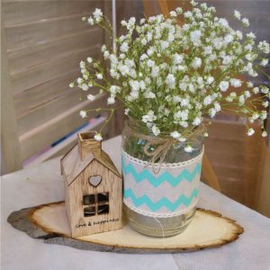 Center piece γιά βαπτιση με ξύλινο κορμό και πάνω DIY βαζάκι με διακόσμηση βεραμα΄ν ύφασμα και λευκή δαντέλα και επιπλέον διακόσμηση ένα ξύλινο σπιτάκι